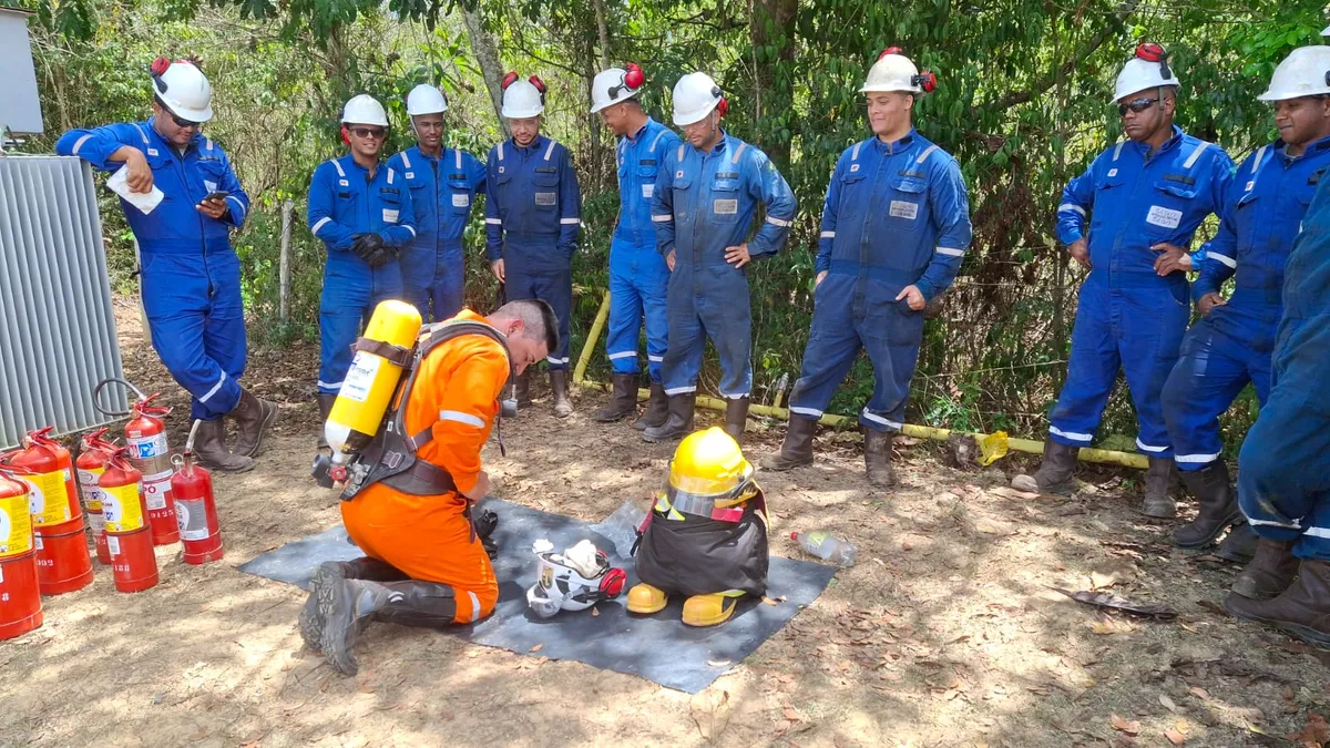 Equipe puxando mangueira de combate a incêndio em simulado